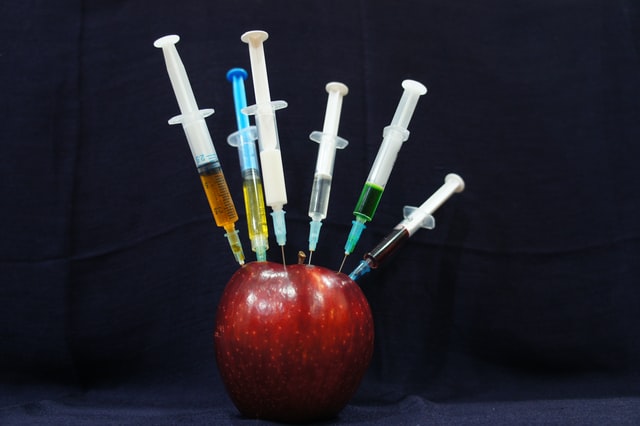 Apple being injected with needles